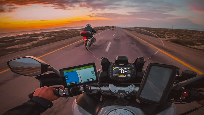 motorcyclists traveling at sunset 