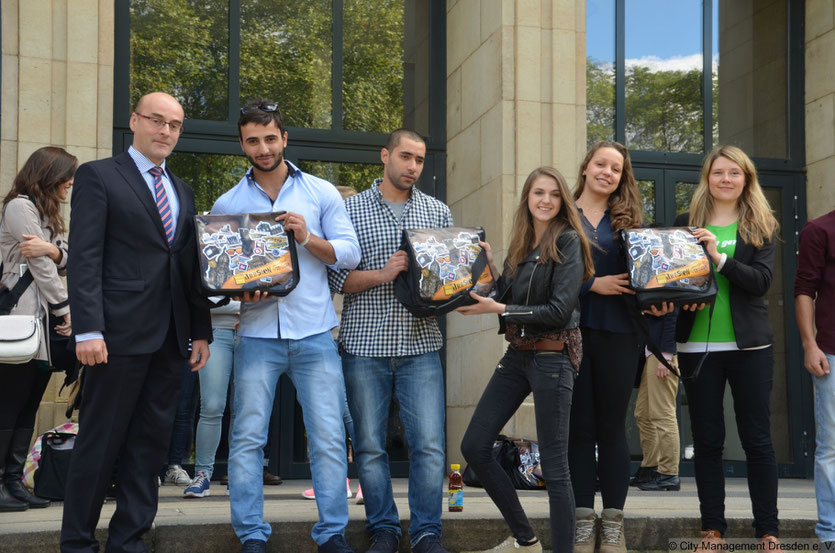 Bei der Pressekonferenz zum Student Welcome Package über geben Steffen Beer *Ostsächsischen Sparkasse (links), Laura Degel *Gestaltung Taschenmotiv (mitte) und Franziska Wilhelm *teilAuto (rechts) die ersten Packages an internationale Studenten der HTW.