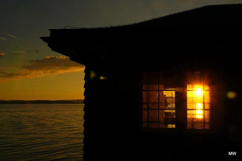 Sonnenuntergang durch Vorder- und Rückfenster eines Bootshauses