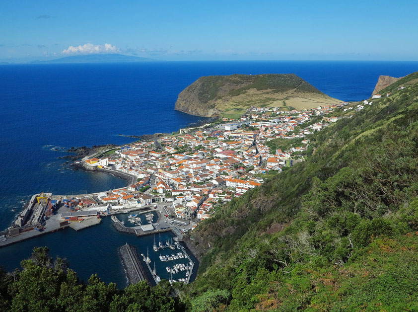 Blick auf Velas mit Hafen, die größte Stadt von São Jorge, am Horizont die Insel Faial