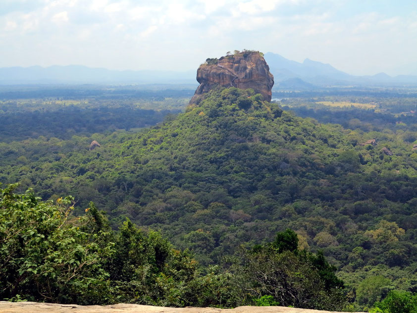 Sigiriya, ein vulkanischer Monolith (Stoßkuppe), auf dem sich die Ruinen einer historischen Felsenfestung befinden. Blick vom benachbarten Felsen Pidurangala