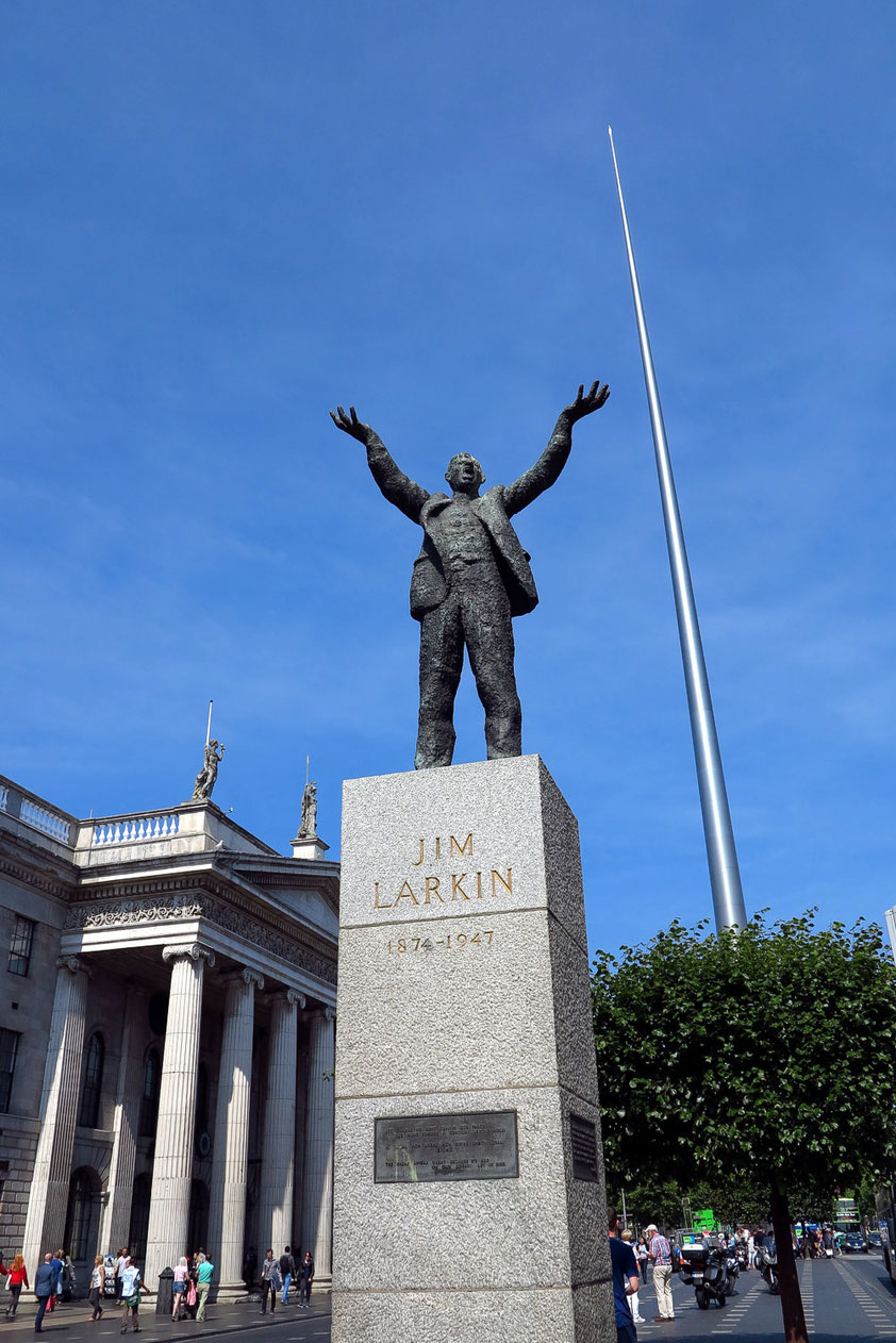 Dublin. Statue des Gewerkschafters James Larkin auf der O'Connell Street,  links General Post Office, ein nationales Denkmal von 1818, rechts der 120 Meter hohe Spire, eine silberglänzende Nadel, neues Wahrzeichen von Dublin.