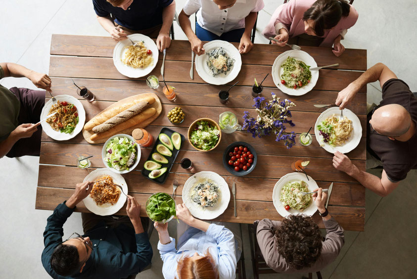 Een tafel waaraan gezellig wordt gegeten door een groepje Alpha deelnemers