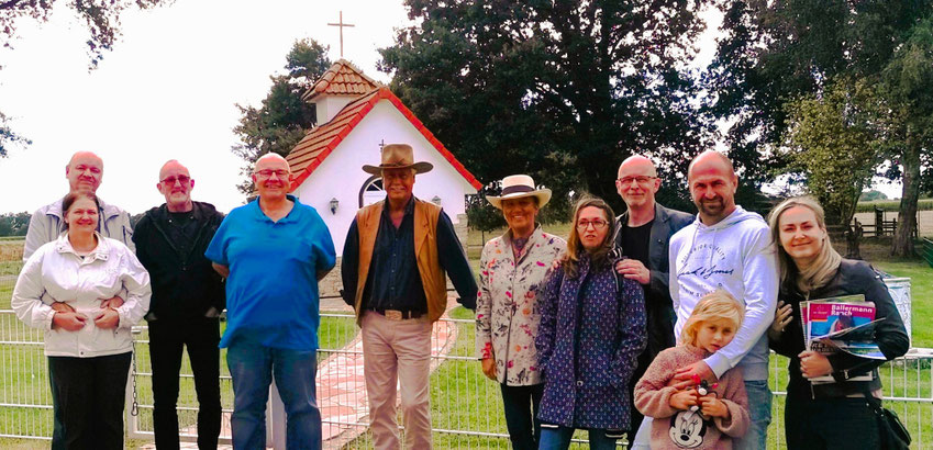 Zweite Besuchergruppe der Freimaurerloge mit Logenmeister Jörg Redenius (li.) und den Ballermann-Ranchern Annette u. André Engelhardt vor der St. Leonhard Kapelle auf der Ballermann Ranch im niedersächsischen Scholen OT Blockwinkel