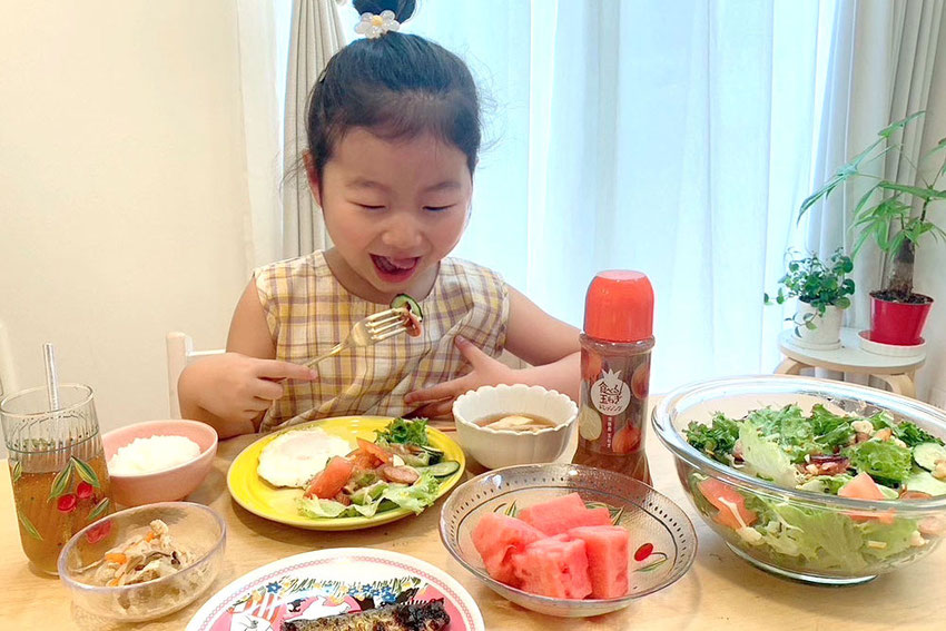 食べる玉ねぎドレッシングをサラダにかけて、美味しく食べる子ども