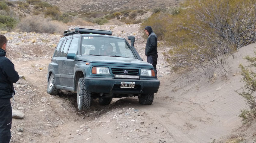 Hernán con su Vitara posando en un cruce de ejes en tres ruedas.