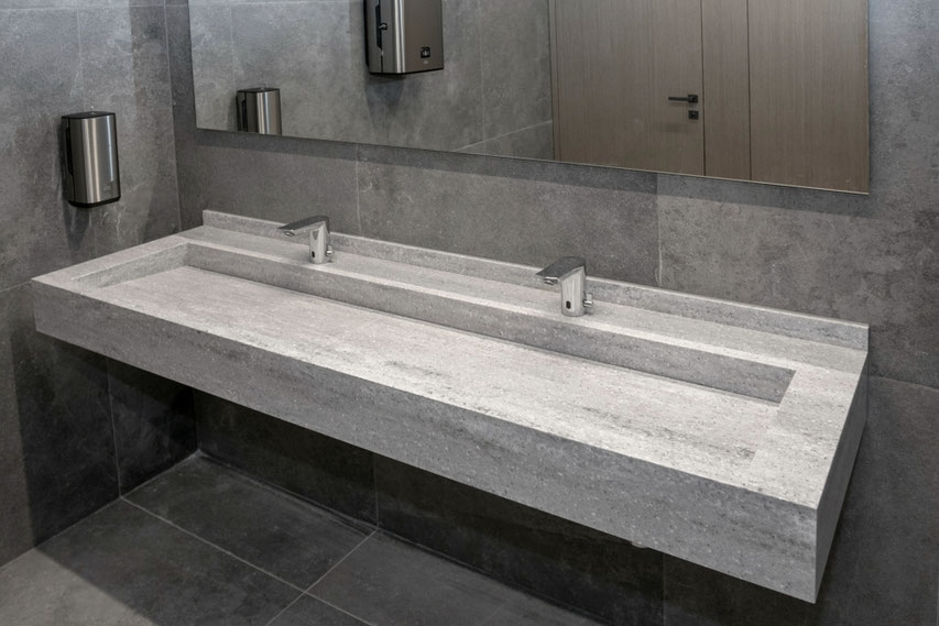 ALIA restrooms are fitted with long double vanities with a water outlet through the edge from acrylic surface
