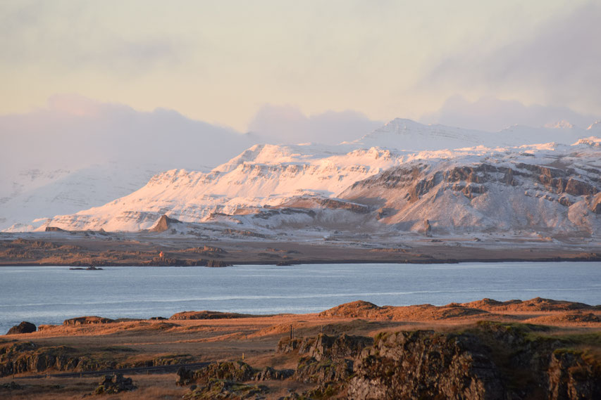 Sunrise on snow across the sea, East Fjords, Iceland