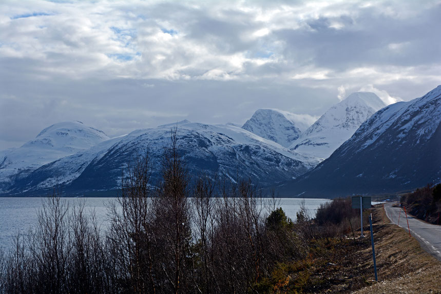 The road down the east side of the Storfjorden with high Lyngen peaks and the steep-sided valley side near Pollfjellet where a rockfall created a tsunami in 1810 that claimed 13 lives.  There is now a grim 3.2km tunnel under Pollfjellet.