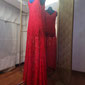 Sur l'image, une robe longue sans manches en dentelle rouge avec un justaucorps rouge en lycra en dessous. Réalisation pour une école de danse.