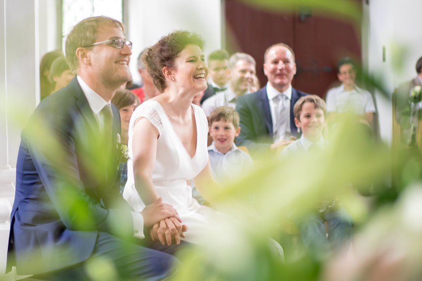Glückliches, lachendes Hochzeitspaar in Hochzeitskapelle in Zug, Hochzeitsfotografie