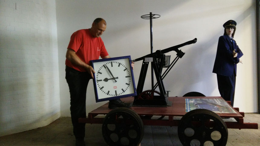 Stefan John, Vorsitzender der Eisenbahnfreunde Wetterau e.V., nimmt die Uhr aus der Bahnhofshalle des Bad Nauheimer Bahnhofs entgegen