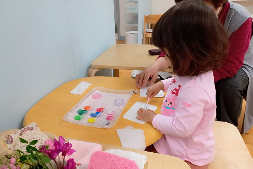 京都市の幼児教室のモンテッソーリ活動で1歳児がのりで貼る活動に取り組んでいます。
