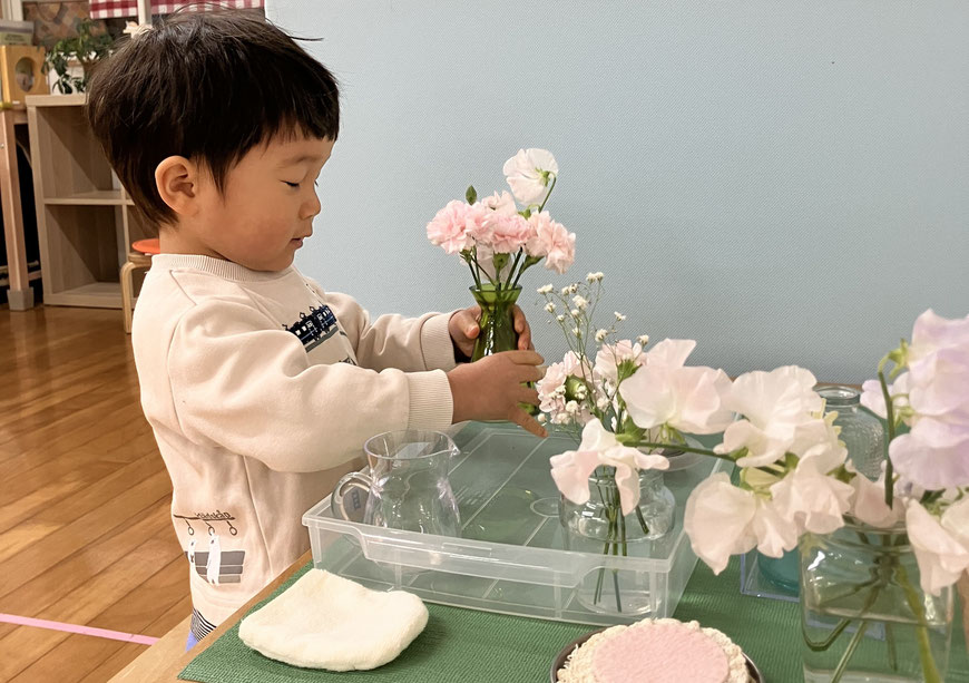 モンテッソーリの活動で、1歳児が活け花の活動を楽しんでいます。