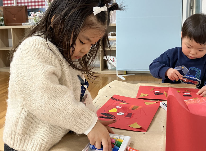 1歳児が、母子分離に向けて、保護者と距離を開けてモンテッソーリの活動に取り組んでいます。