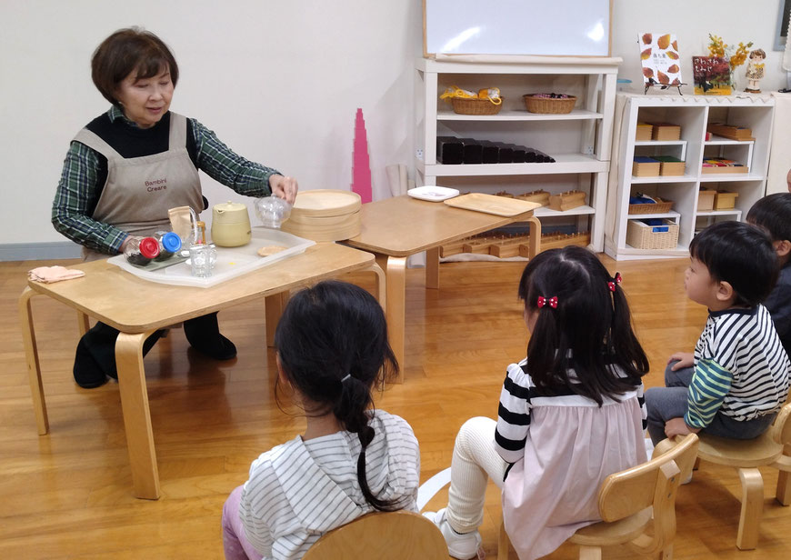幼稚園児がモンテッソーリの活動で、お茶を入れる提示を集中してみています。