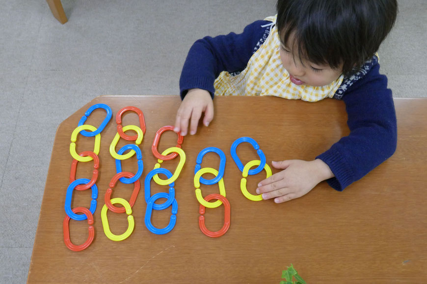 京都市の幼児教室バンビー二クレアーレ。モンテッソーリの個別活動で2歳児がチェーンを数に合わせて順番に並べています。