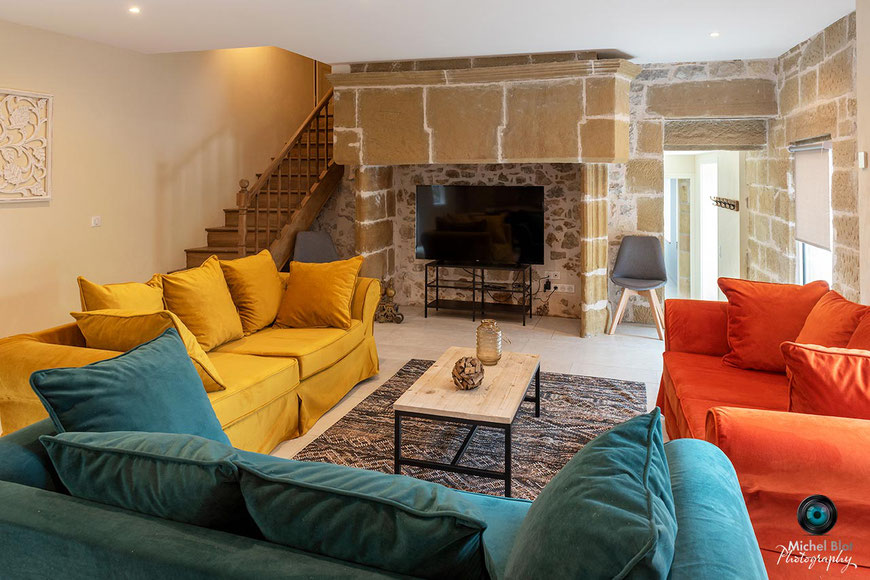 canapé jaune orange bleu pétrole cheminée chateau lissac cantou en pierre decoration authentique