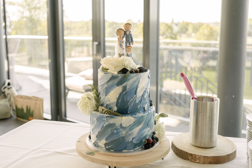 Hochzeitstorte mit Tortenfiguren mit einem Kind und einer Katze