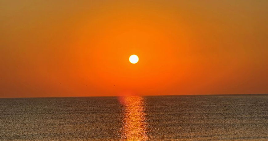 Orangefarbener Sonnenuntergang über dem Meer – Symbol für Leichtigkeit als Mutter