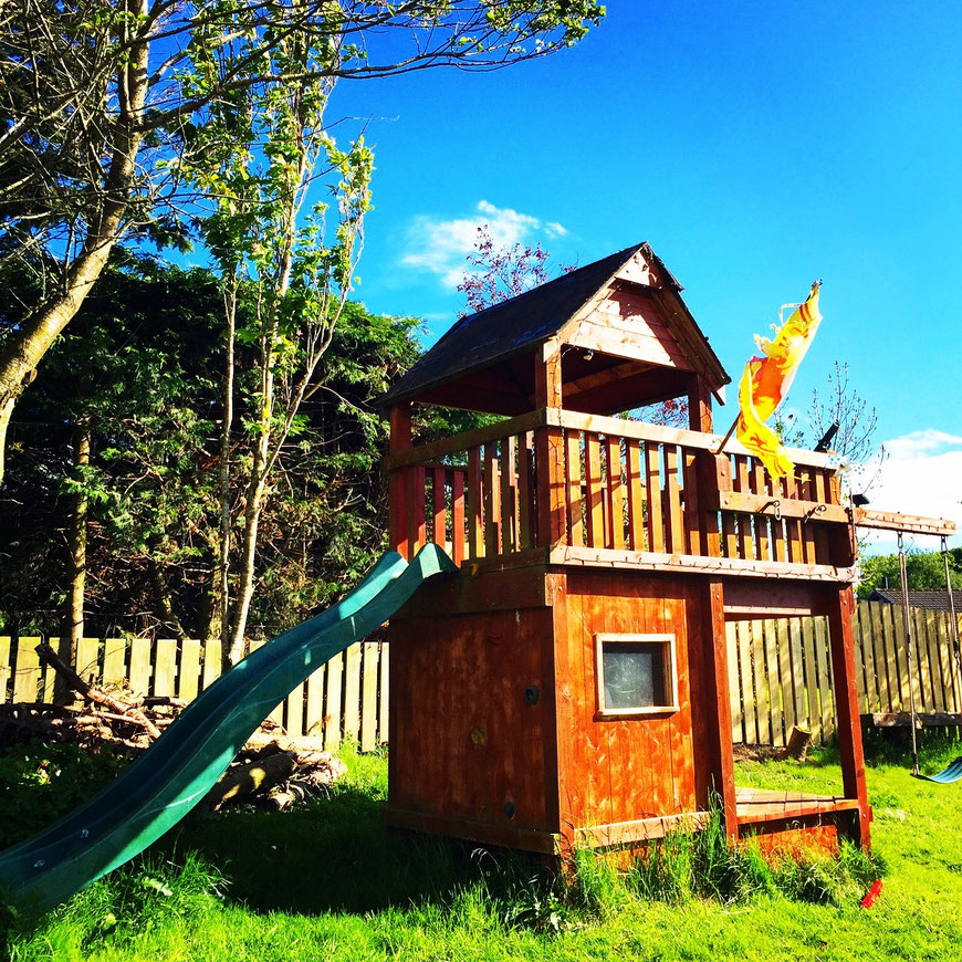 Handmade outdoor play fort built from reclaimed timber in a Scottish garden