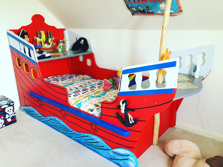 Handmade pirate ship bed with wooden mast and painted hull details