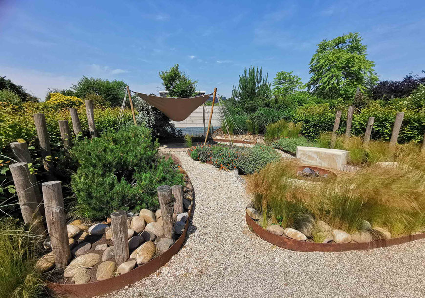 Strandgarten, moderner Garten mit Cortenstahl, Gräsern und Holzpfählen