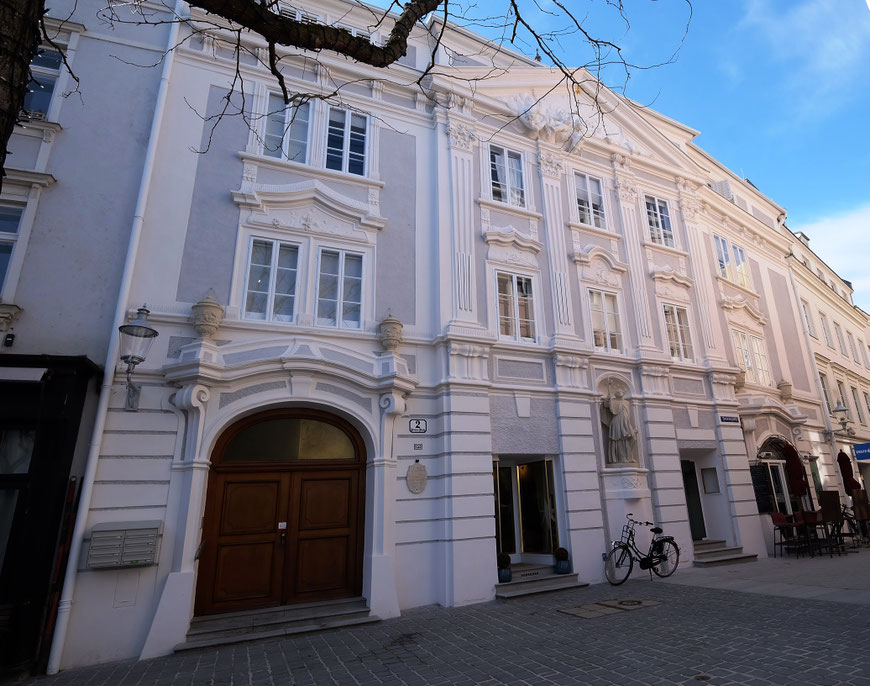 Die Fassade nach erfolgter Restaurierung. Das bauzeitliche Farbkonzept mit grauen Nullflächen und weißer Gliederung wurde restauratorische befundet und umgesetzt.