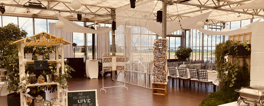 Festlich dekorierter Wintergarten im Jägers Gewächshaus Nürnberg mit Candybar und DJ-Equipment für stilvolle Hochzeitsfeier