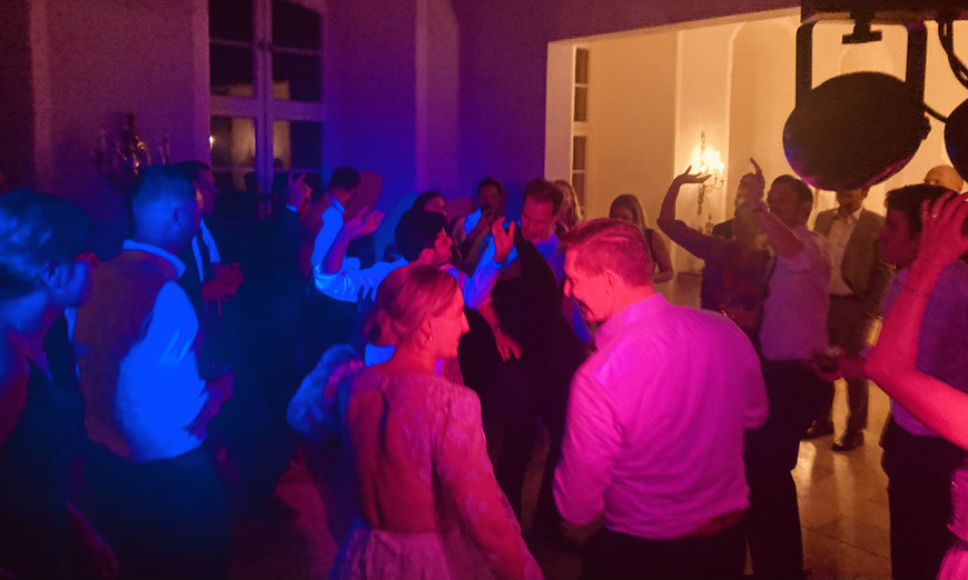 Tanzende Gäste auf der Hochzeitsfeier im Schloss Jägersburg – volle Tanzfläche und ausgelassene Partyatmosphäre mit DJ