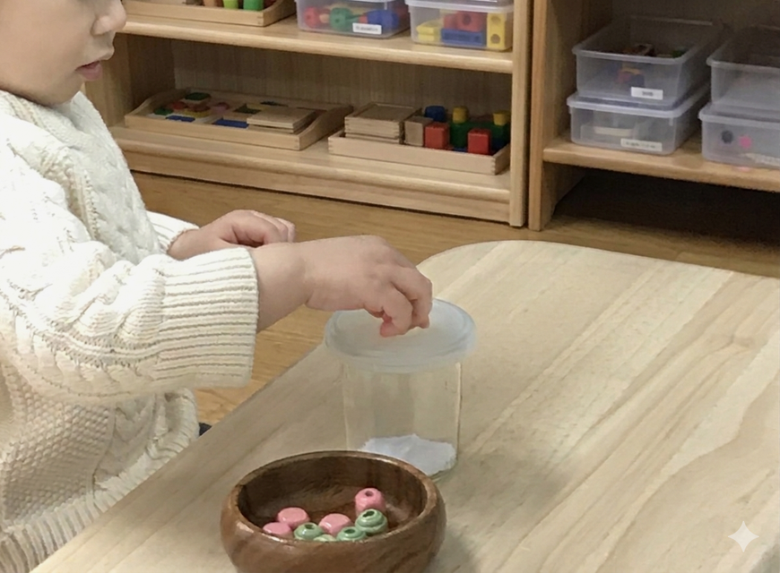京都の幼児教室でボール落としに集中する1歳児の様子