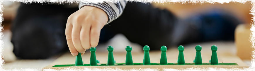 Kind spielt mit grünen Spielsteinen bei den Glückskindern Hofheim