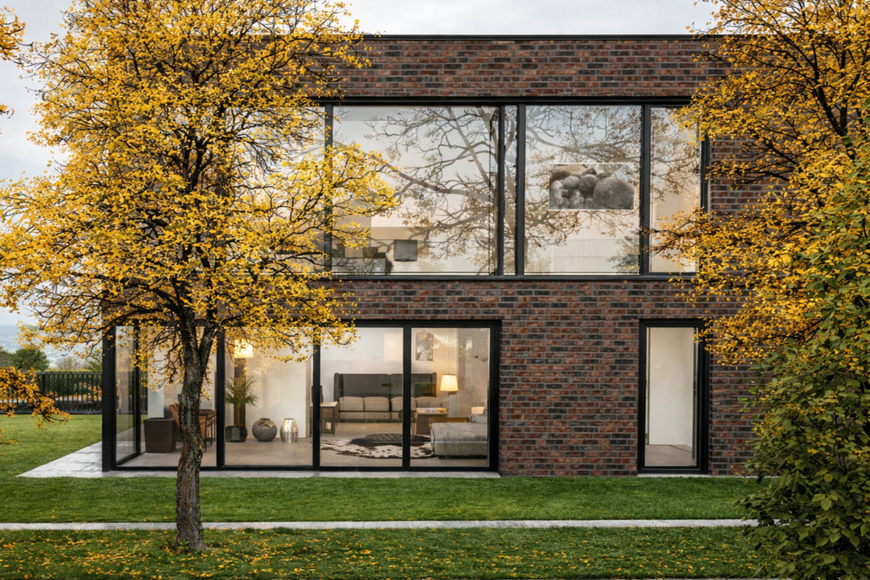 Seitenasicht Bauhausvilla am Hang mit Terrasse und minimalistischem Garten