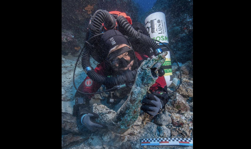 archaeologist recovering bronze arm from Antikythera shipwreck