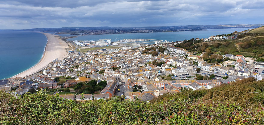 Blick vom Aussichtspunkt beim Heights Hotel auf Chesil Beach und den Hafen von Portland