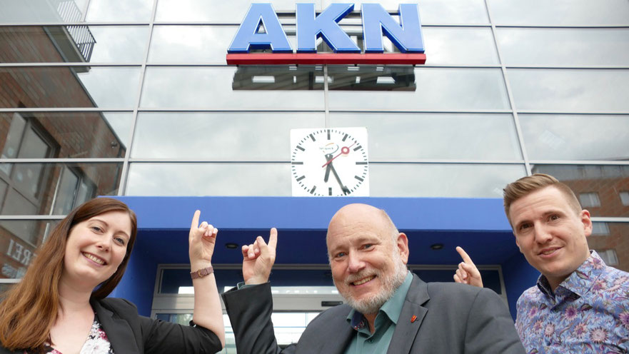 Jeannine Müller, Vertriebsleiterin der Stadtwerke Quickborn GmbH, Bürgermeister Thomas Beckmann und Helge Tiemann, Pressesprecher der Stadt Quickborn, freuen sich über die neue Bahnhofsuhr