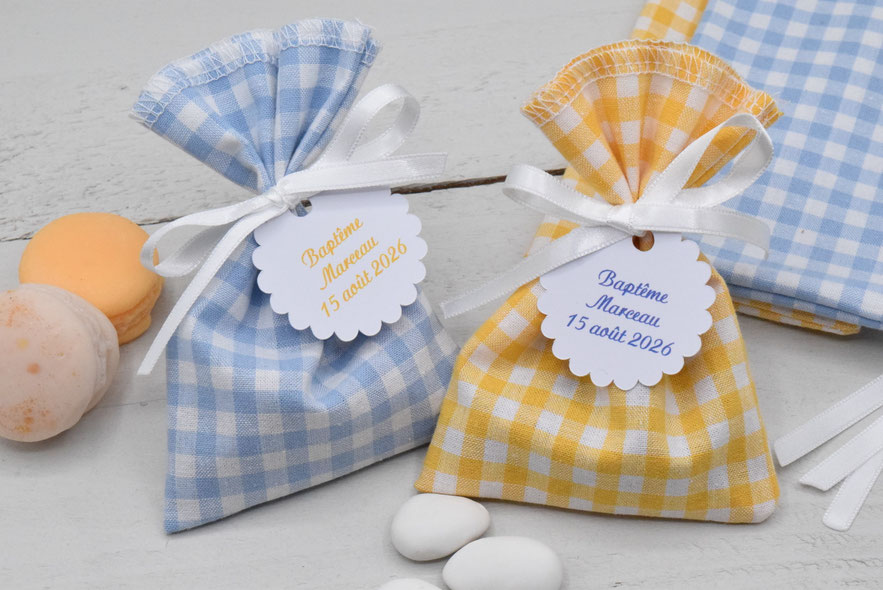 pochons dragées personnalisés tissu coton vichy bleu ciel et jaune citron  avec étiquette ronde dentelé inscription "baptême marceau 15 aout 2026"