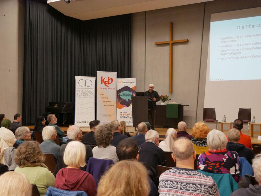 Imam Kadir Sanci stellt vor knapp 120 Zuhörern das interreligiöse Friedens- und Bauprojekt House of One Berlin vor.