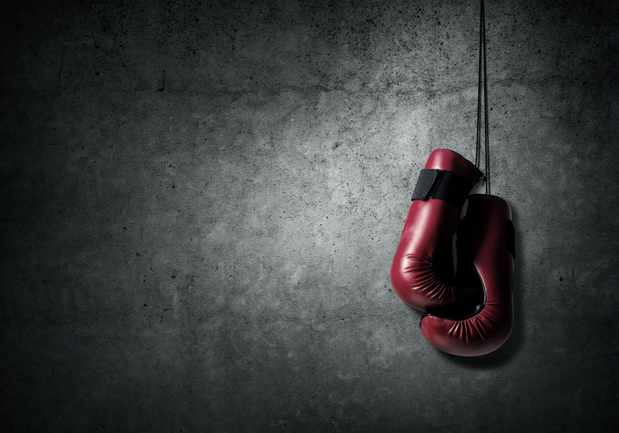 Boxhandschuhe hängen an einer Wand