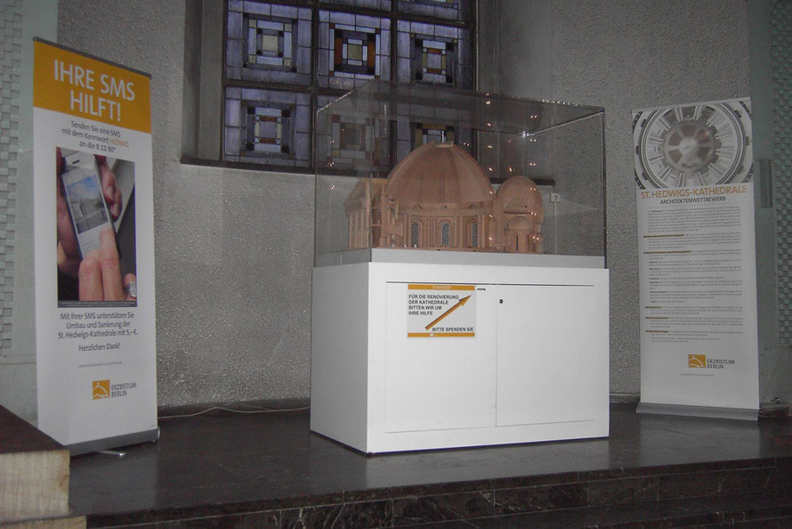 Propaganda des Erzbistums 2014 – 2016 in einer Nische der St. Hedwigs-Kathedrale: Aufruf zum Simsen in der Kathedrale, mit dem Begriff "Renovierung" für radikalen Umbau Geld sammeln und eine Tafel mit Fehlinformationen zu dem geplanten Umbau
