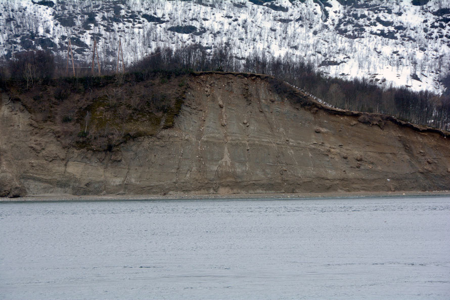 An ice-front delta  near Jøvik on the Ullsfjorden deposited during the Younger Dryas glaciations when the sea level was 65m higher than today. The glacier nose was to the left and the delta was deposited by a meltwater stream. NB telegraph poles for scale