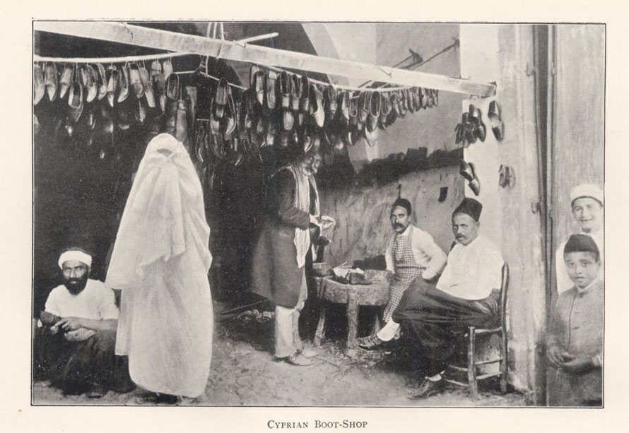 Turkish men and children and one veiled woman gathered about a boot shopUnknown Cyprian Boot-Shop (1900). From Travelers in the Middle East Archive (TIMEA). http://hdl.handle.net/1911/10019 