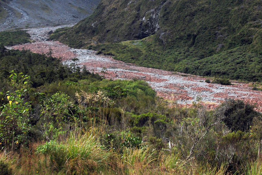 The outwash and pink/red-stained debris in the Hollyford riverbed on the approach to the Homer Tunnel on the Milford Road.