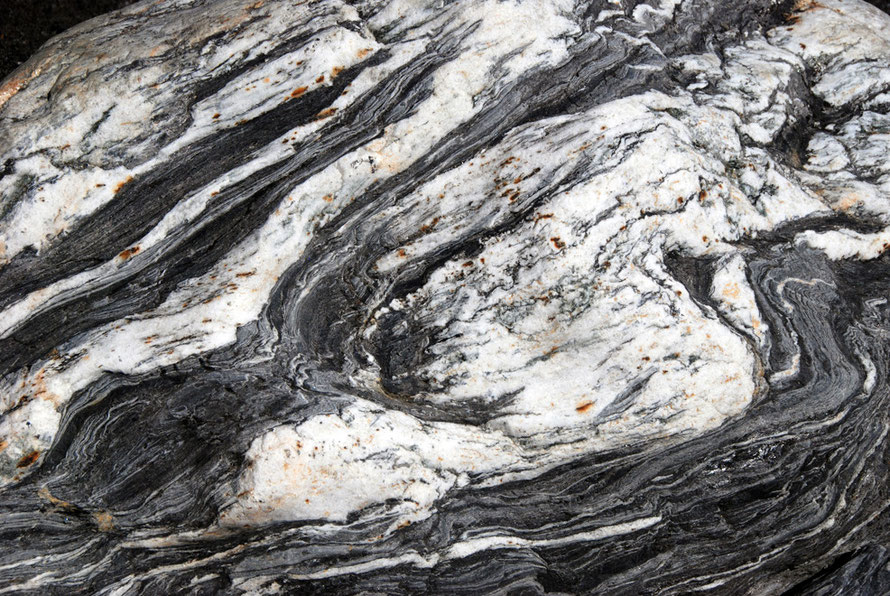 Minor folds - like drag folds in miniature - in quartzite schist boulders at Mill Stream in the Fox Glacier region