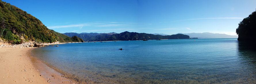 Panoramic view of Wainui Bay from near Taupo Point with Abel Tasman Point and the distant Wakamarama mountains to the west.