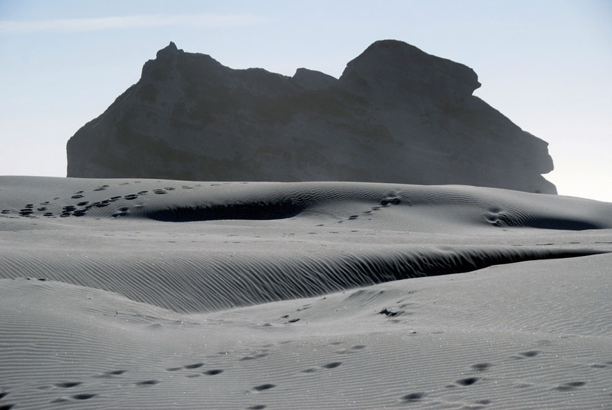 Wind blown sand and massive rock formations at Wharariki Beach west of Golden Bay.