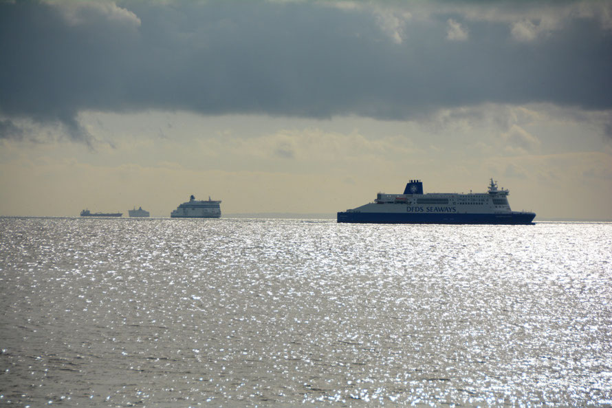 An array of ferries and shipping with the French coast in the background. 