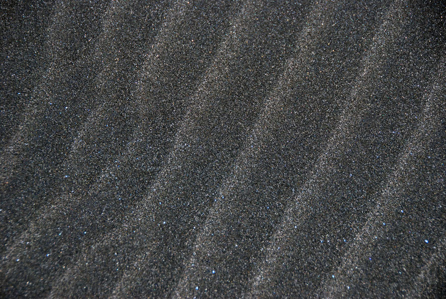 The black volcanic sand of Karakere Beach glittering with mica and quartz and hot as hell. 