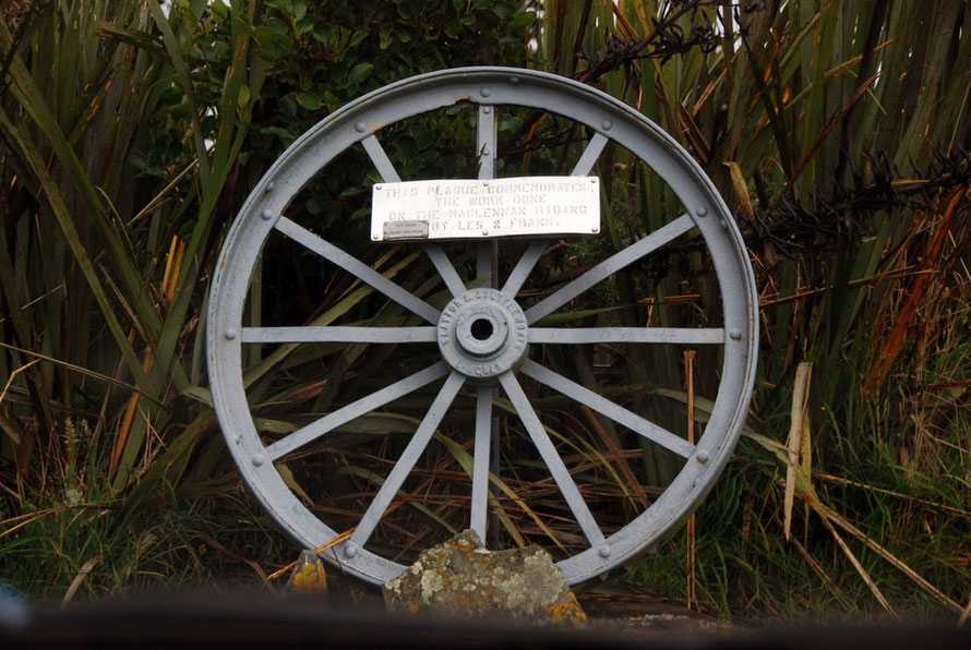 Between Clutha and Tautuka on a steel tractor wheel: 'This plaque commemorates the work done on the Maclennan Riding by Les and Frank: Les Dewe Frank Chalmers'.