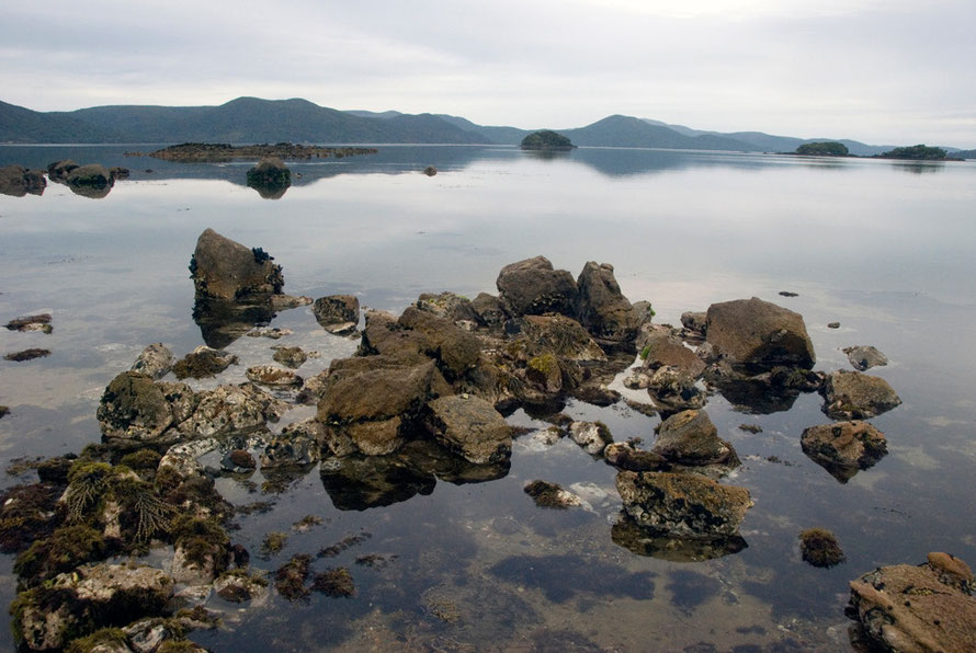 The incoming tide at Boulder Beach, Ulva with Tamihau Island and Pryse Peak (352m) to right and location of hunters huts at Abrahams and Hapuatuna Bays.